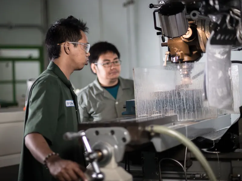 Kỹ thuật viên trao đổi bên máy gia công trong xưởng