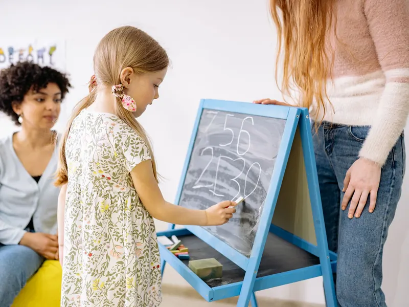 Bé tập viết trên bảng phấn nhỏ