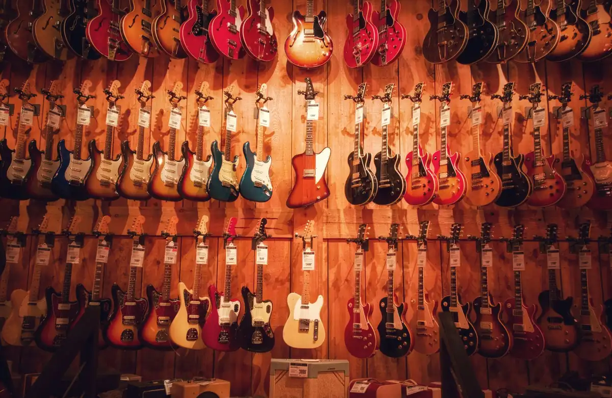 Bức tường treo nhiều cây guitar điện trong cửa hàng nhạc cụ