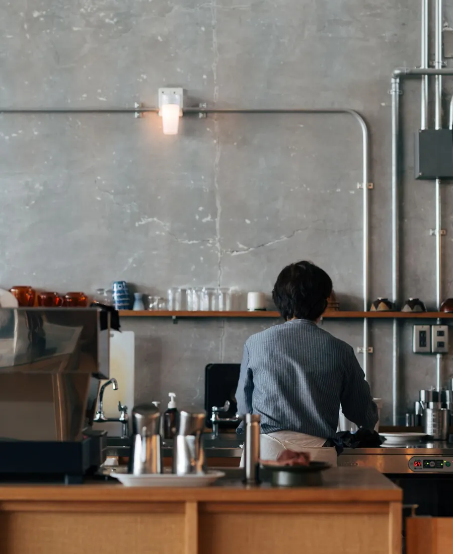 Barista đứng sau quầy pha chế tối giản