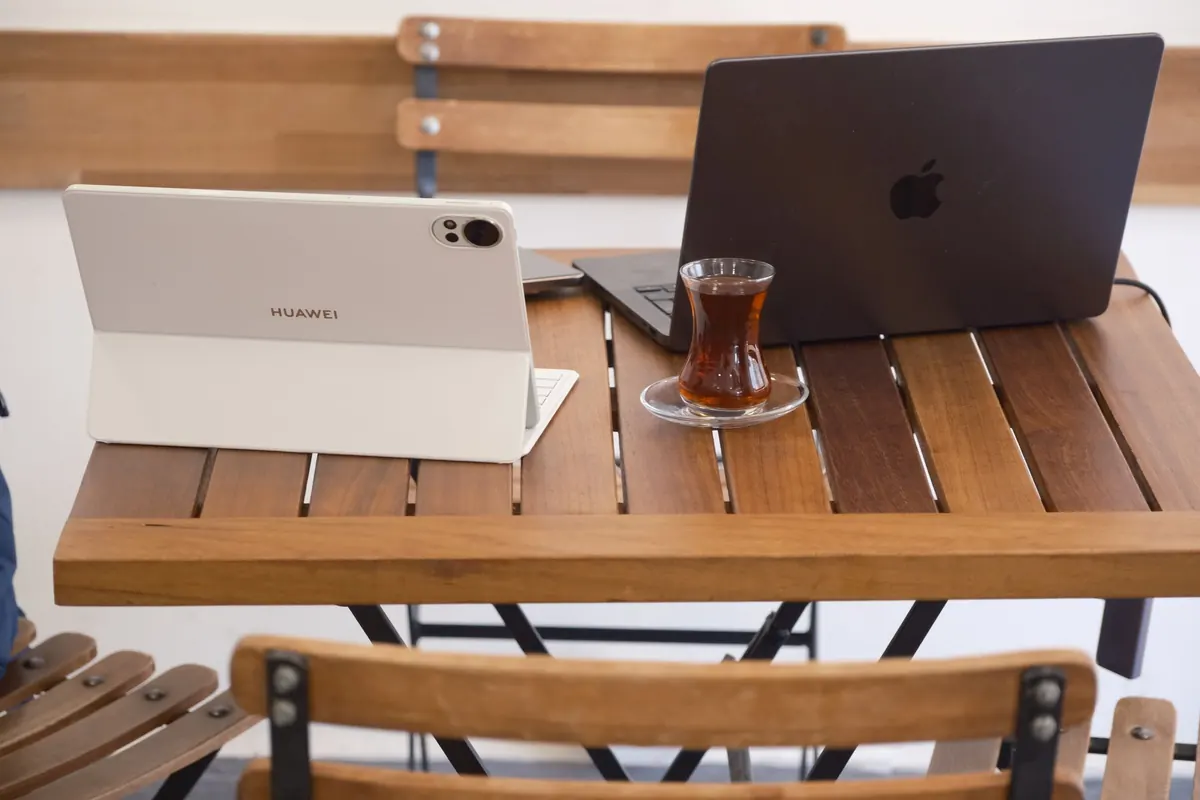Laptop và máy tính bảng trên bàn gỗ ngoài hiên