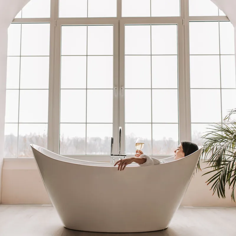 Bồn tắm trắng cạnh cửa sổ lớn