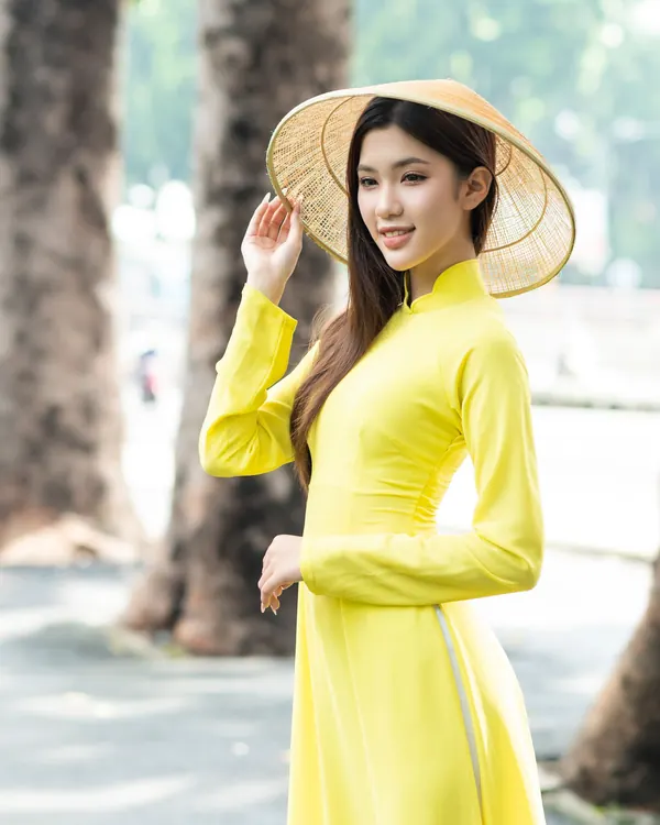 Người mẫu mặc áo dài vàng nghệ du xuân
