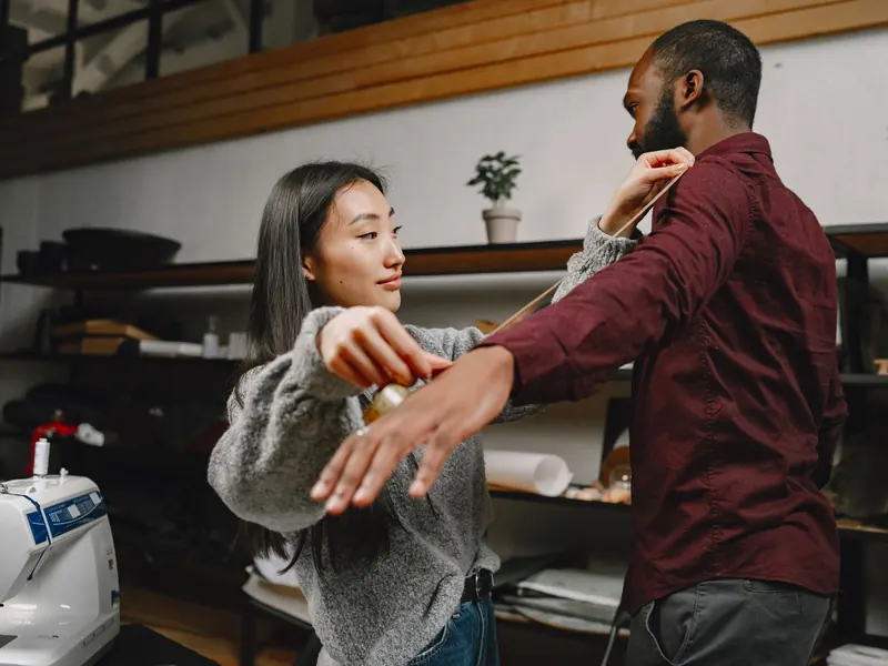 Thợ may đang đo số đo cho khách