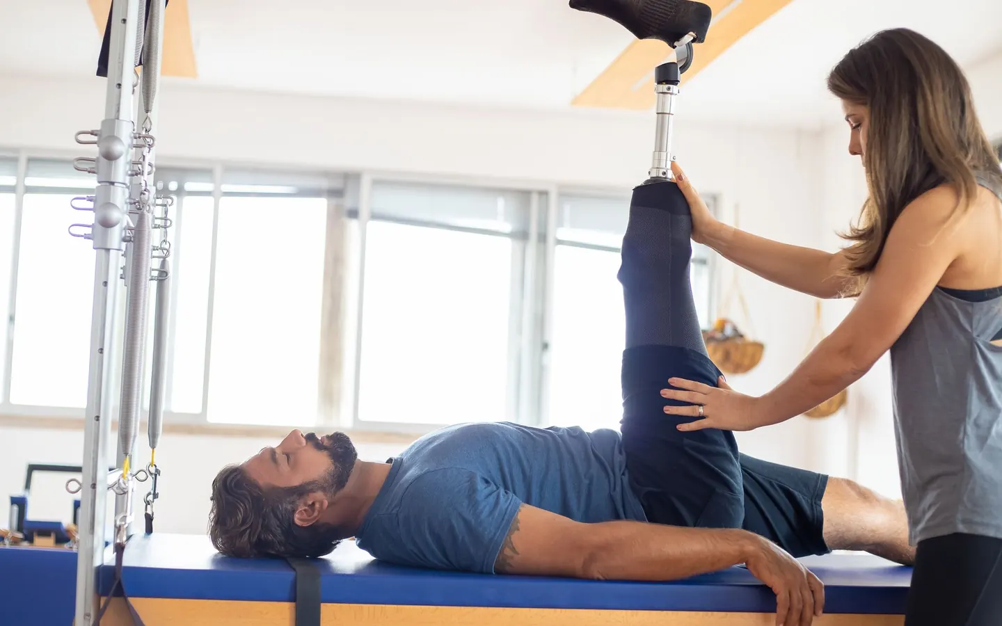 Chuyên viên vật lý trị liệu đang hướng dẫn khách tập trên giường